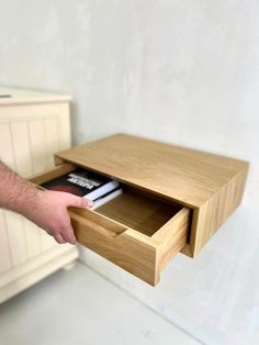 a person holding a book in their hand near a drawer with an open file cabinet