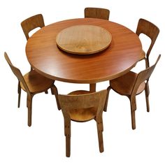 a wooden table with four chairs around it and a plate on top of the table