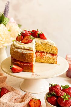 a cake with strawberries and whipped cream on top sits on a red platter