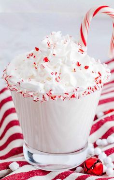 a white cup filled with whipped cream and candy canes