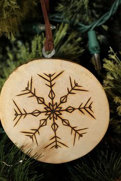 a snowflake ornament hanging from a christmas tree