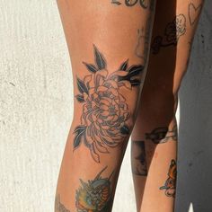 two women with tattoos on their legs and one has a flower tattoo on her leg