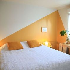 a white bed sitting in a bedroom next to a window