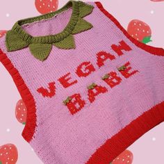 a pink sweater that says vegan baby on it with strawberries in the background