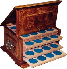 a wooden jewelry box with blue polka dots on the lid and bottom drawer, open