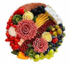 a platter filled with different types of meats, cheeses and fruit on top of each other