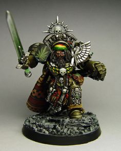 a miniature warhammer with a green light saber in his hand and an elaborate helmet on it's head