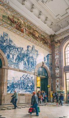 people are walking around in an ornate building with murals on the walls and ceilinging