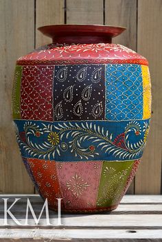 a colorful vase sitting on top of a wooden table