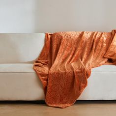 an orange blanket draped over a white couch