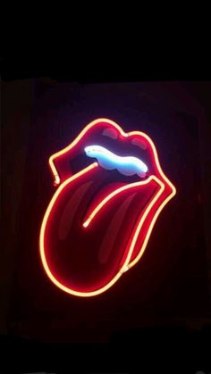 the rolling stones logo is lit up in red, white and blue colors on a black background