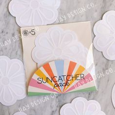 the suncather badge is on top of some paper flowers