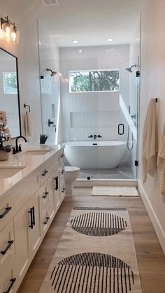 a bathroom with a bathtub, sink and rugs on the floor in front of it