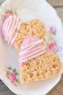 three desserts on a plate with pink and white icing, one is heart shaped