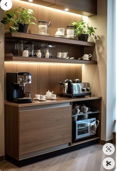 a coffee maker and some cups on top of a wooden shelf with lights above it