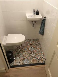 a white toilet sitting next to a sink in a bathroom