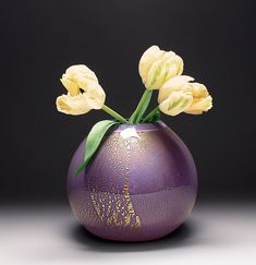 a purple vase with yellow flowers in it