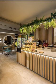 the interior of a restaurant with plants hanging from the ceiling