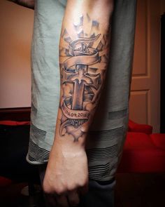 a man with a cross tattoo on his arm