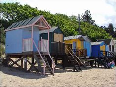 a row of beach huts sitting next to each other on top of a sandy beach