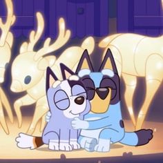 two cartoon cats sitting next to each other in front of a light up deer statue