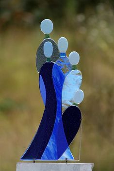 a blue and white sculpture sitting on top of a metal stand