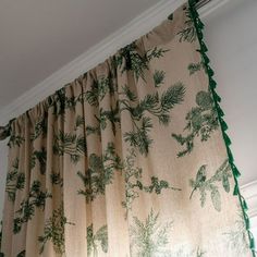 the curtains are hanging on the ceiling in the living room, with pine trees printed on them