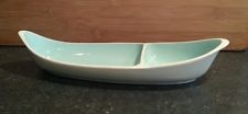 a white boat shaped bowl sitting on top of a counter