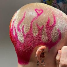 a man with pink hair has his head shaved