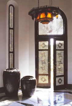 two large vases sitting on top of a marble floor next to an open door