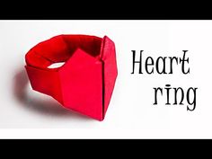 an origami heart ring sitting on top of a piece of paper with the words heart ring written across it