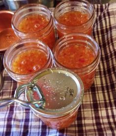 several jars filled with food sitting on top of a checkered table cloth next to measuring spoons