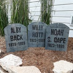 three tombstones with names on them in front of a house