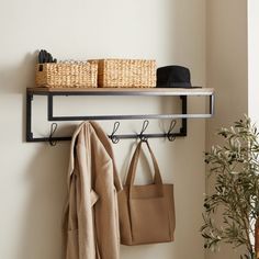 a coat rack with two coats hanging on it and some bags next to it,