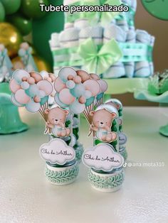 two teddy bears are holding balloons in front of some baby shower items on a table