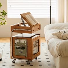 an open book is sitting on top of a cart in the middle of a living room