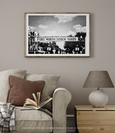 a black and white photo hanging on the wall above a couch with an open book