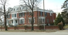 a red brick building with white trim on the front and side of it's windows