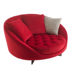 a red round couch with two pillows on it's back and the seat upholstered