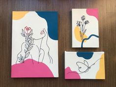 three pieces of art on a table with flowers and leaves painted on them, including two square coasters