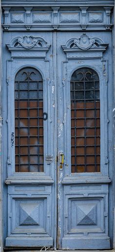 an old blue door with two windows on it