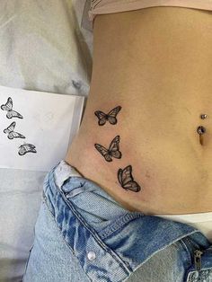 a woman's stomach with three butterflies on it