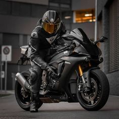 a man riding on the back of a black motorcycle