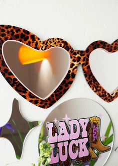 two heart shaped mirrors with lady luck stickers on them