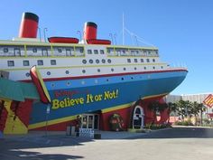 a large cruise ship sitting in the middle of a parking lot next to a building