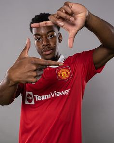 a man in a red shirt is making the vulcan sign with his hands and fingers