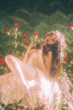 a woman sitting in a chair surrounded by flowers