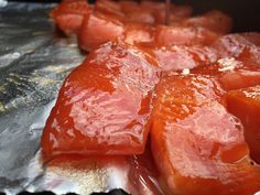 raw meat is being cooked on the grill with water pouring from a bottle over it