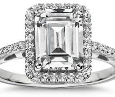 an emerald cut diamond ring with diamonds around it