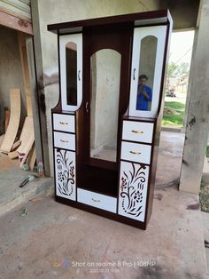 a white and brown armoire sitting on top of a floor